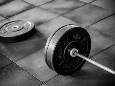 Iron weights lying on a dark rubber gym mat.